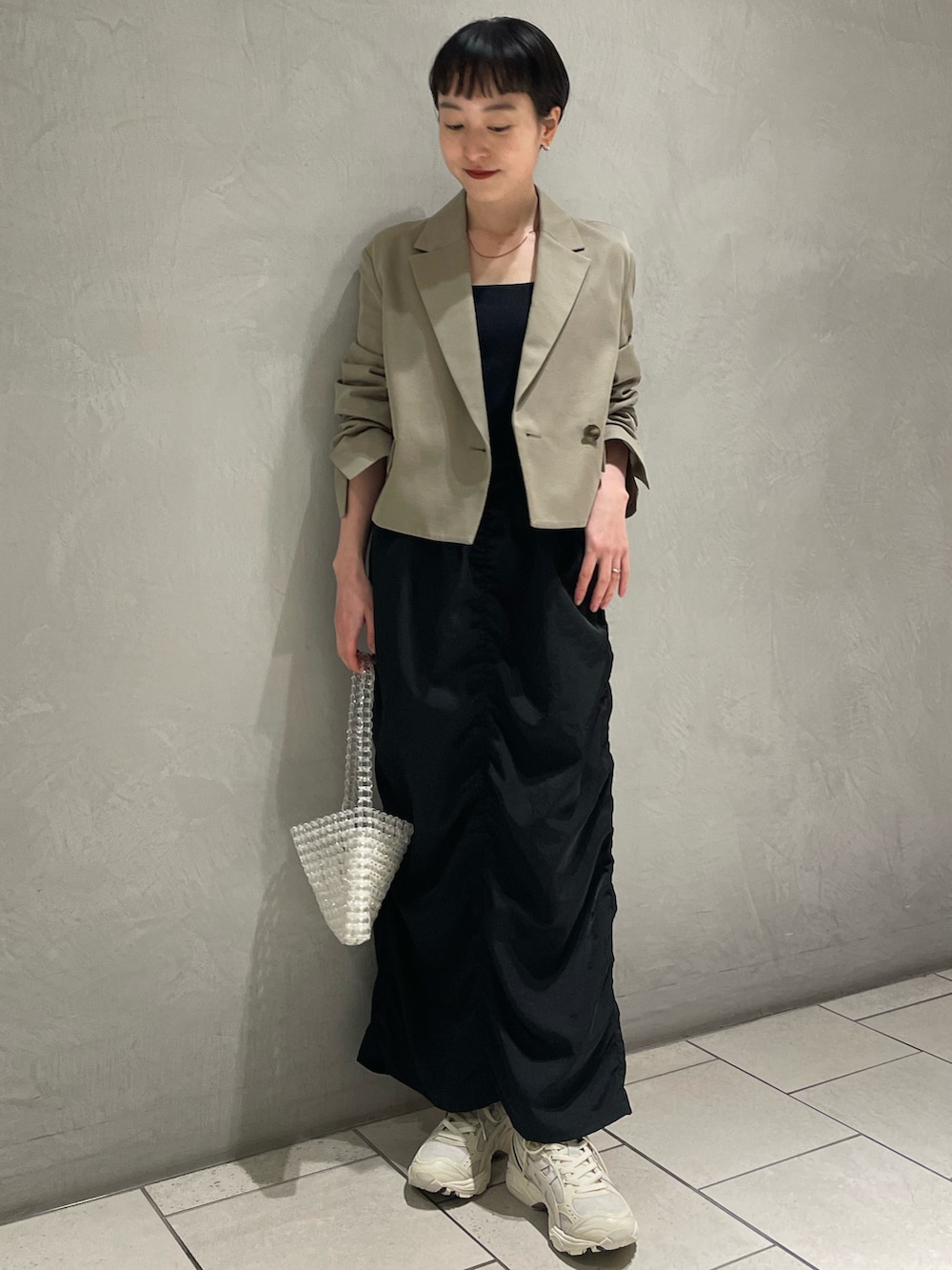 グリーン系のテーラードジャケット、ブラック系のキャミソール、ブラック系のスカートを着用したレディースの春コーディネートの2枚目の写真