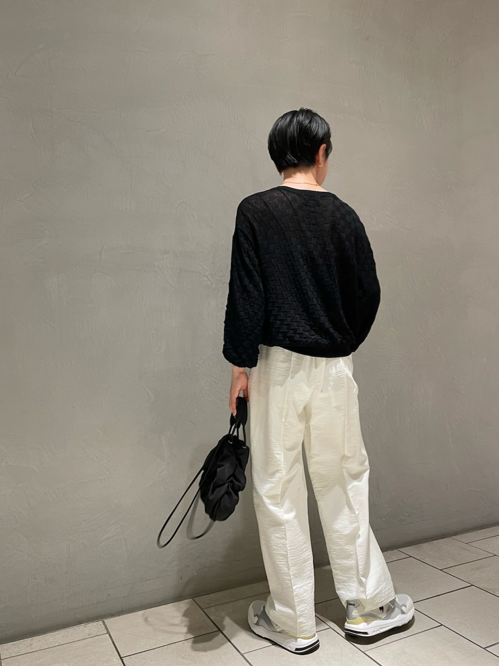 ブラック系のキャミソール、ブラック系のニット/セーター、ホワイト系のその他パンツを着用したレディースの春コーディネートの3枚目の写真