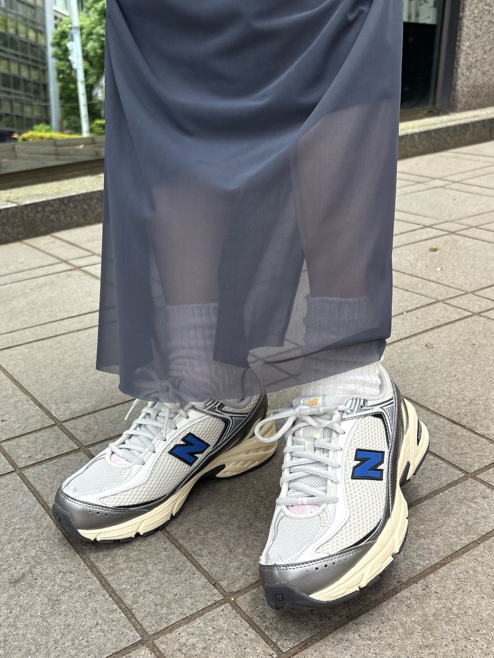 ホワイト系のタンクトップ、ブルー系のスカート、ブラウン系のショルダーバッグを着用したレディースの夏コーディネートの4枚目の写真