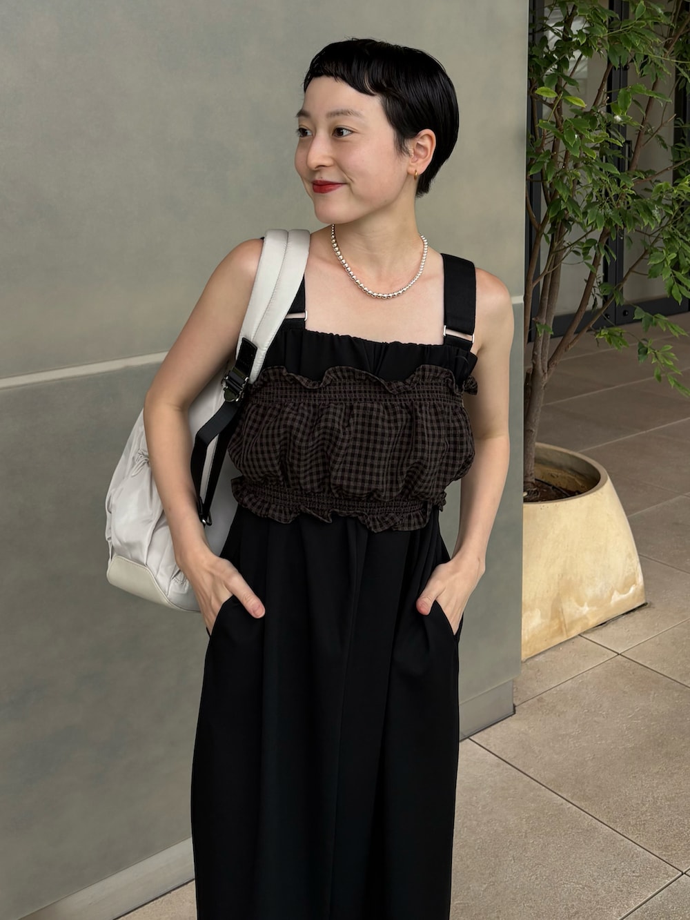 ブラウン系のシャツ/ブラウス、ブラック系のスカート、ホワイト系のバックパック/リュックを着用したレディースの夏コーディネートの5枚目の写真