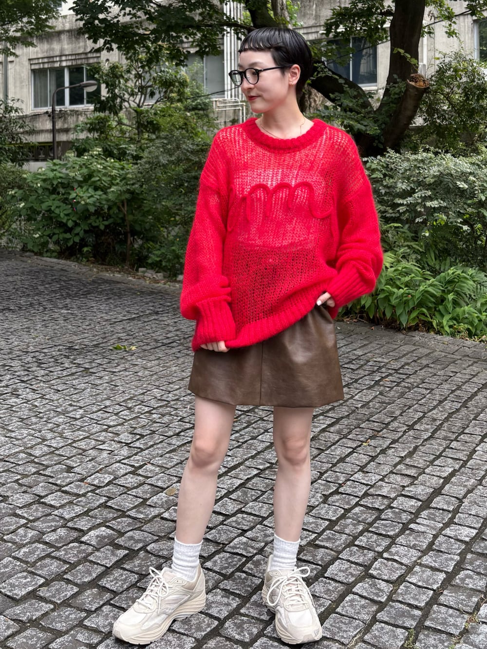 ブラウン系のブルゾン、レッド系のニット/セーター、ブラウン系のスカートを着用したレディースの夏コーディネートの2枚目の写真