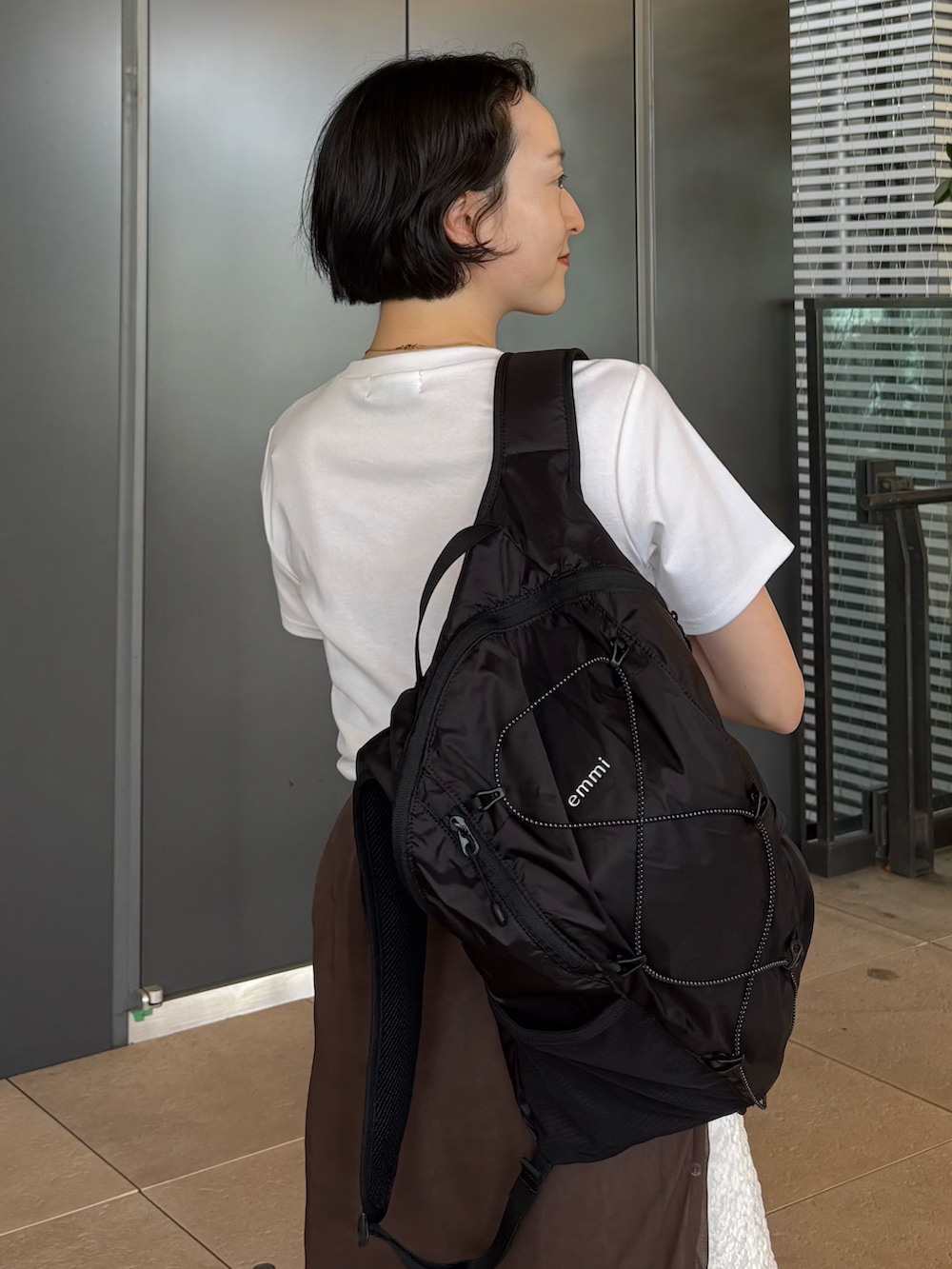 ホワイト系のTシャツ/カットソー、ホワイト系のスカート、ブラック系のバックパック/リュックを着用したレディースの夏コーディネートの5枚目の写真