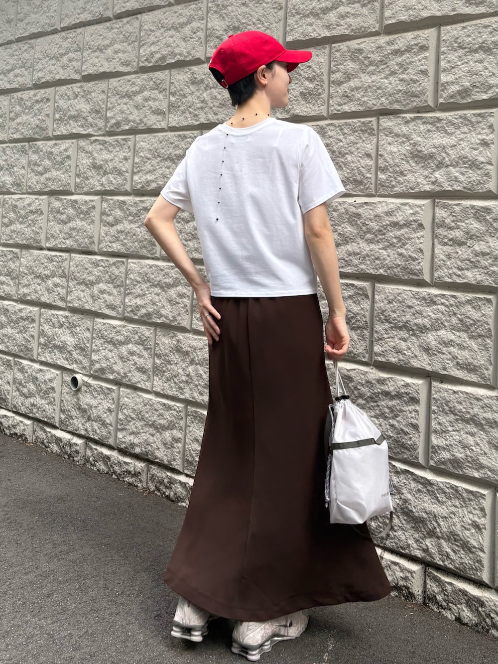 ホワイト系のTシャツ/カットソー、ブラウン系のスカート、グレー系のショルダーバッグを着用したレディースの夏コーディネートの3枚目の写真
