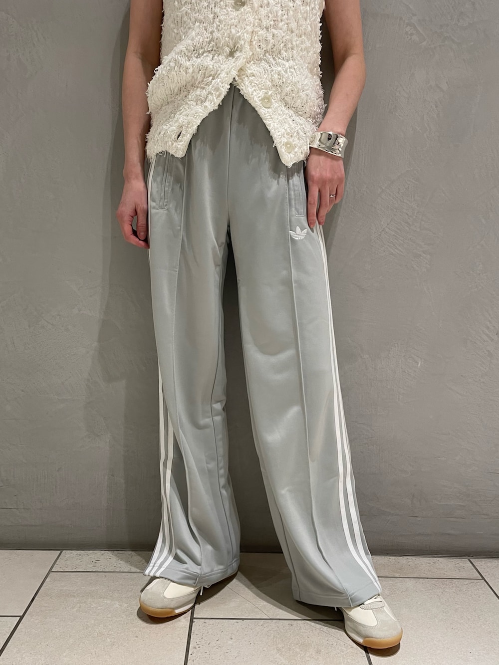 ホワイト系のニット/セーター、ホワイト系のスニーカー、ホワイト系のハンドバッグを着用したレディースの春コーディネートの4枚目の写真