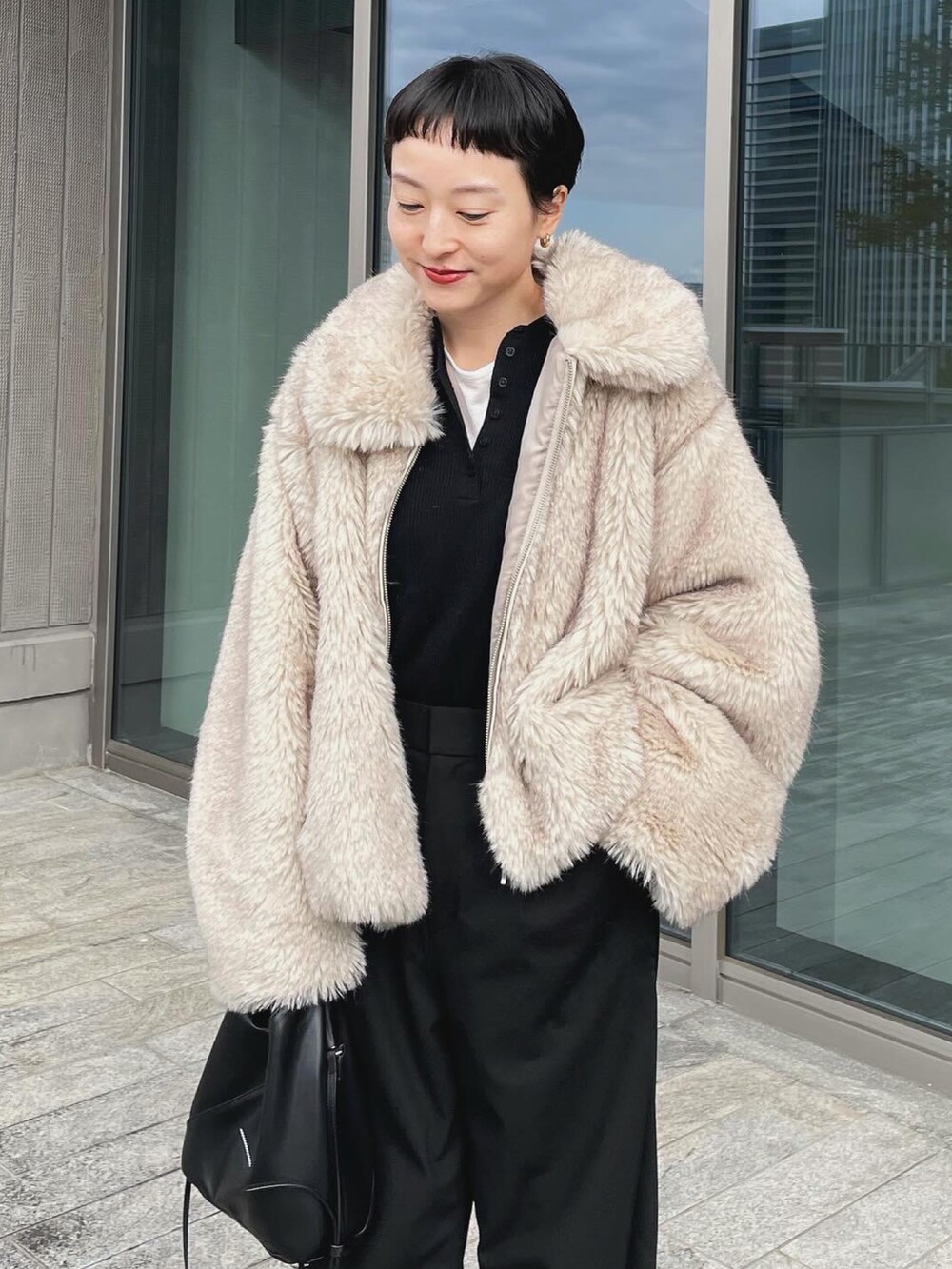 ベージュ系のその他アウター、ブラック系のパンツ、ブラック系のショルダーバッグを着用したレディースの冬コーディネートの2枚目の写真