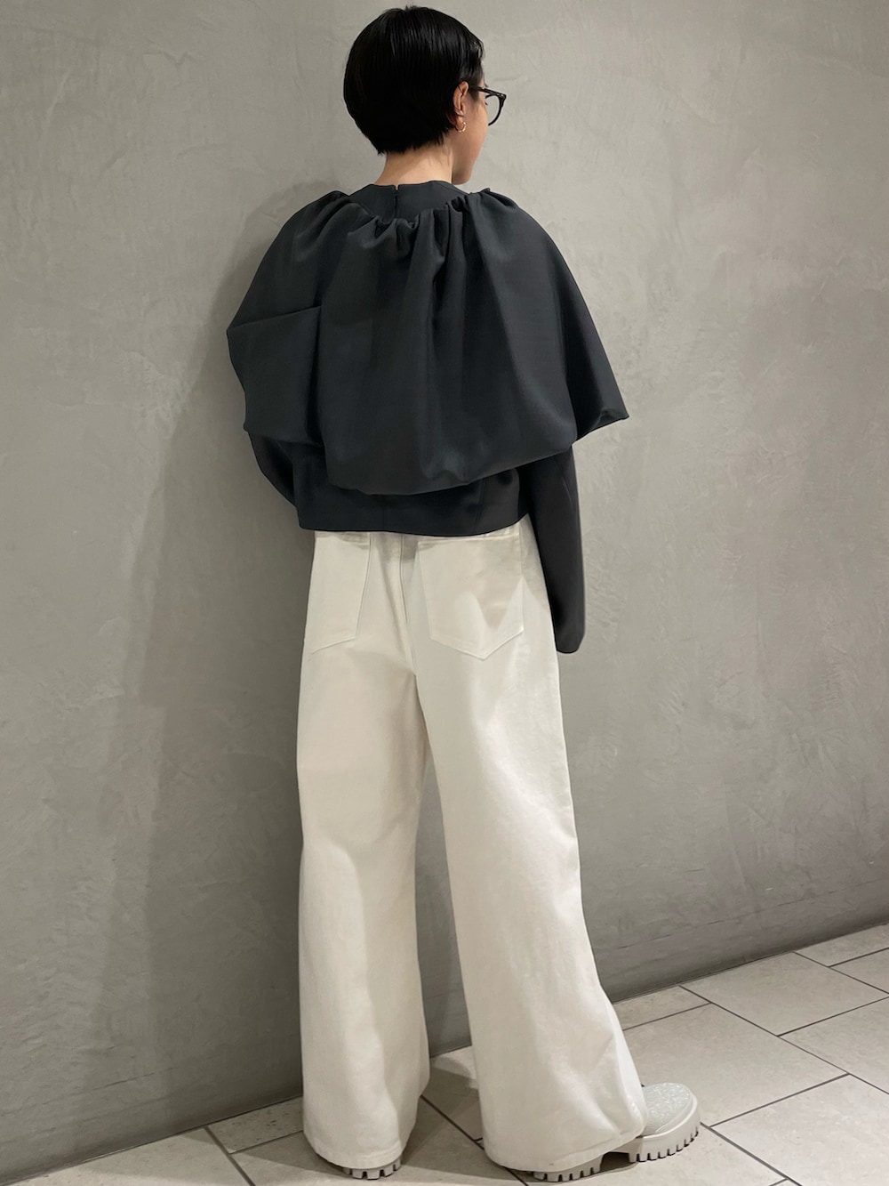 グレー系のTシャツ/カットソー、ホワイト系のデニムパンツ、シルバー系のブーツを着用したレディースの春コーディネートの2枚目の写真