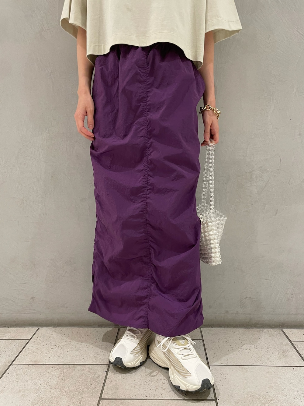 グリーン系のTシャツ/カットソー、パープル系のスカート、その他のハンドバッグを着用したレディースの夏コーディネートの5枚目の写真