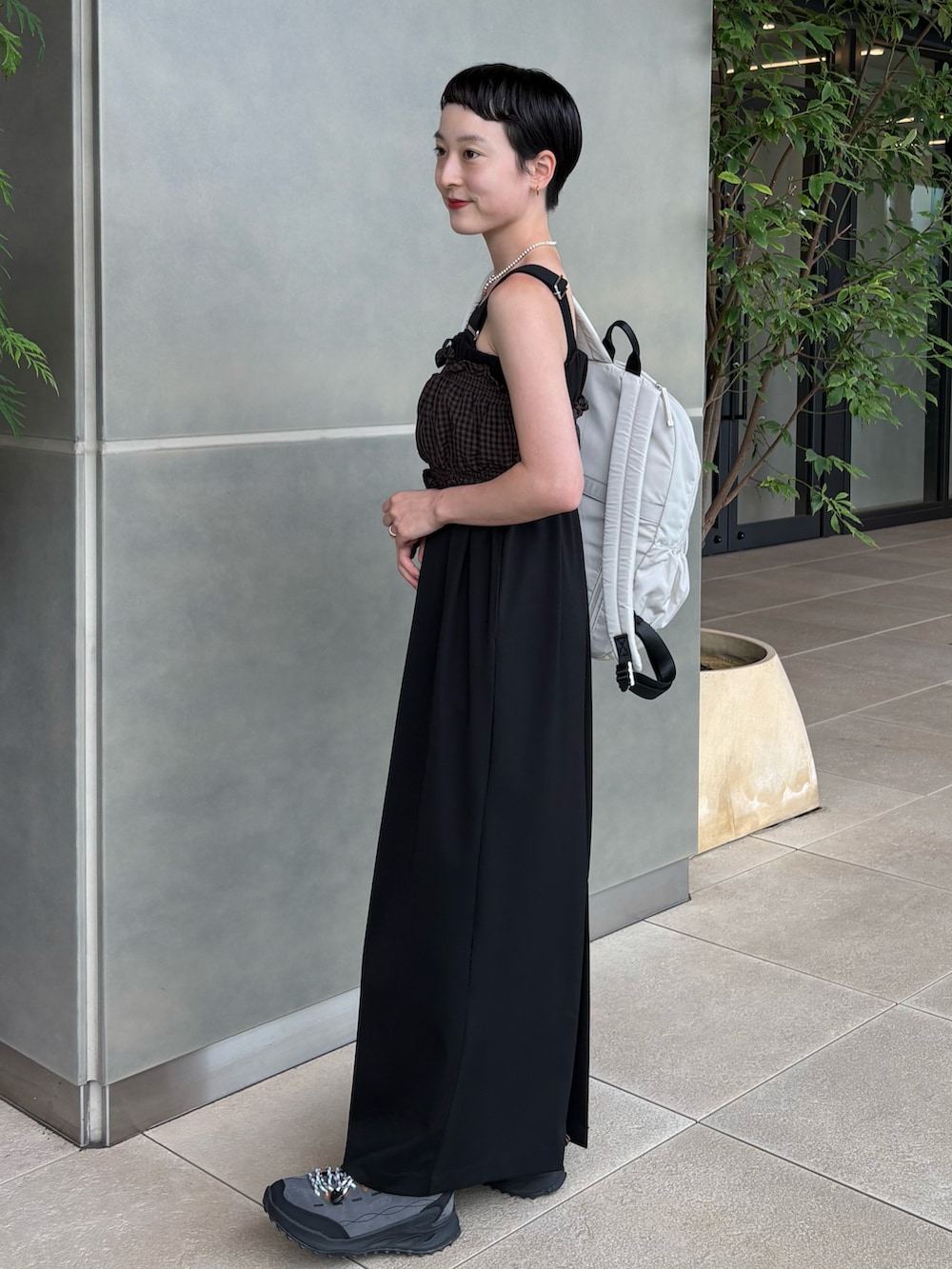 ブラウン系のシャツ/ブラウス、ブラック系のスカート、ホワイト系のバックパック/リュックを着用したレディースの夏コーディネートの2枚目の写真