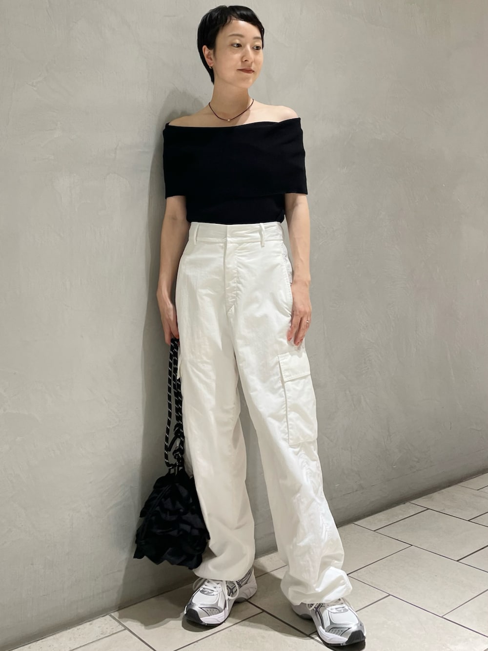 ブラック系のニット/セーター、ホワイト系のその他パンツ、ブラック系のショルダーバッグを着用したレディースの秋コーディネートの2枚目の写真