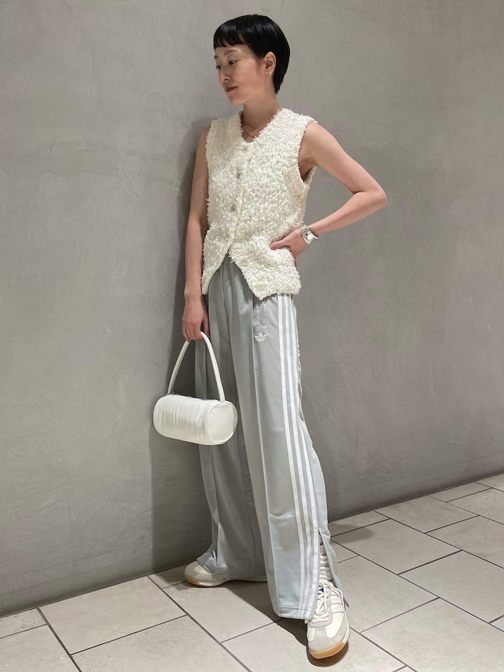ホワイト系のニット/セーター、ホワイト系のスニーカー、ホワイト系のハンドバッグを着用したレディースの春コーディネートの2枚目の写真