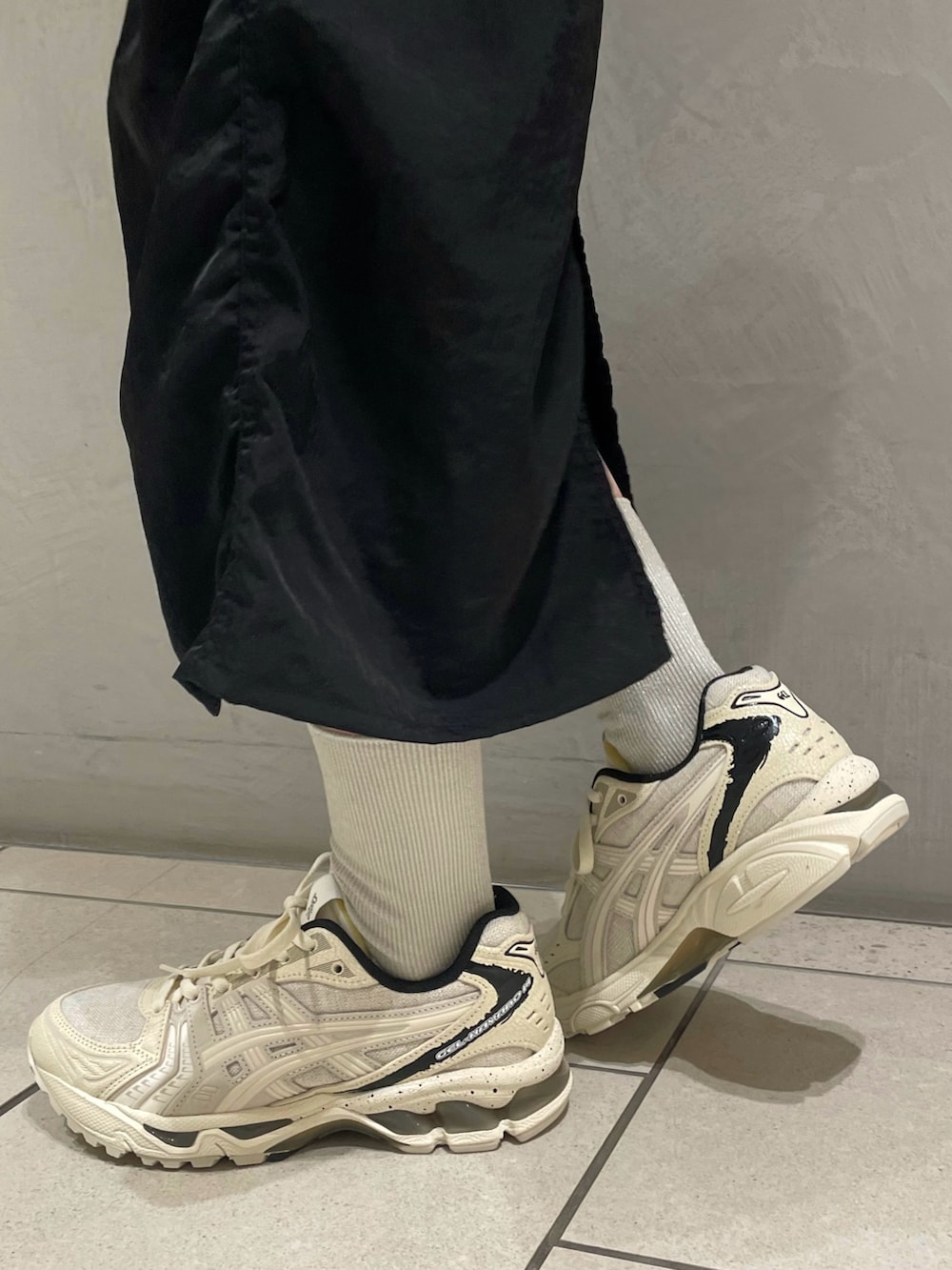 グリーン系のテーラードジャケット、ブラック系のキャミソール、ブラック系のスカートを着用したレディースの春コーディネートの5枚目の写真