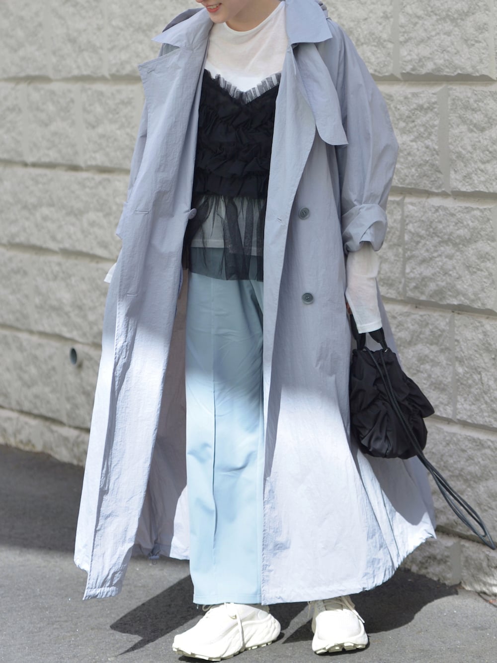ブルー系のスウェットパンツ、ブルー系のトレンチコート、ホワイト系のTシャツ/カットソーを着用したレディースの春コーディネートの2枚目の写真