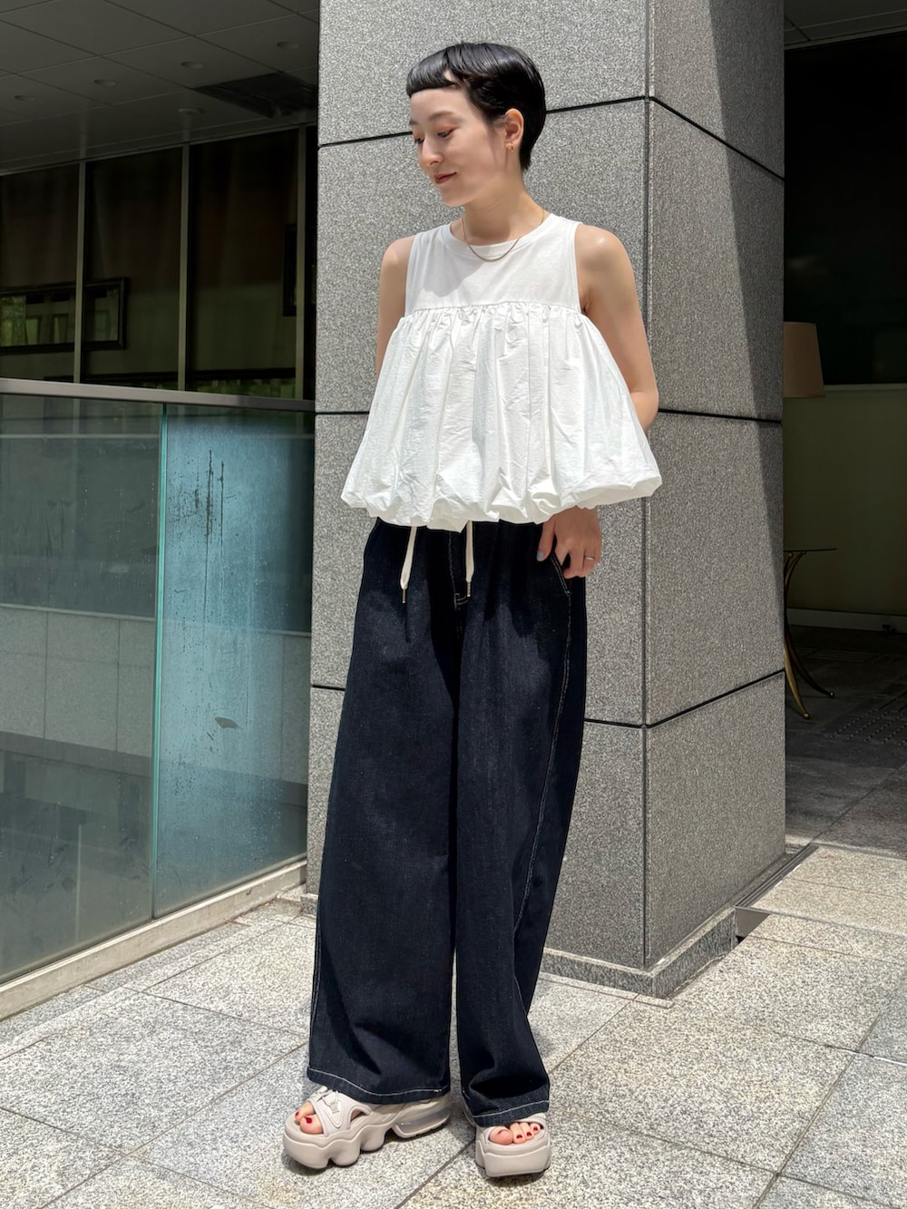 ホワイト系のシャツ/ブラウス、ブルー系のその他パンツ、オレンジ系のバックパック/リュックを着用したレディースの夏コーディネートの4枚目の写真