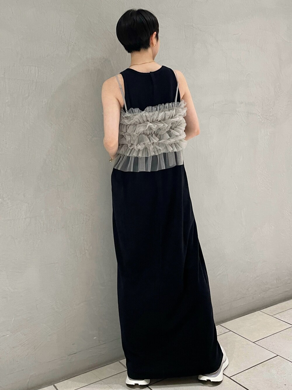 グレー系のキャミソール、ブラック系のワンピース、ブルー系のスニーカーを着用したレディースの夏コーディネートの3枚目の写真