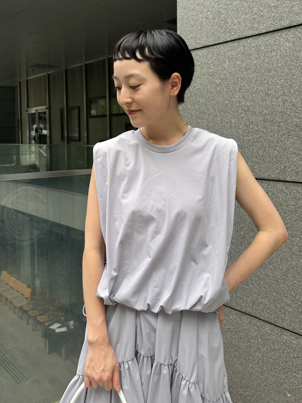 ブルー系のワンピース、ホワイト系のハンドバッグ、ブルー系のスニーカーを着用したレディースの夏コーディネートの3枚目の写真