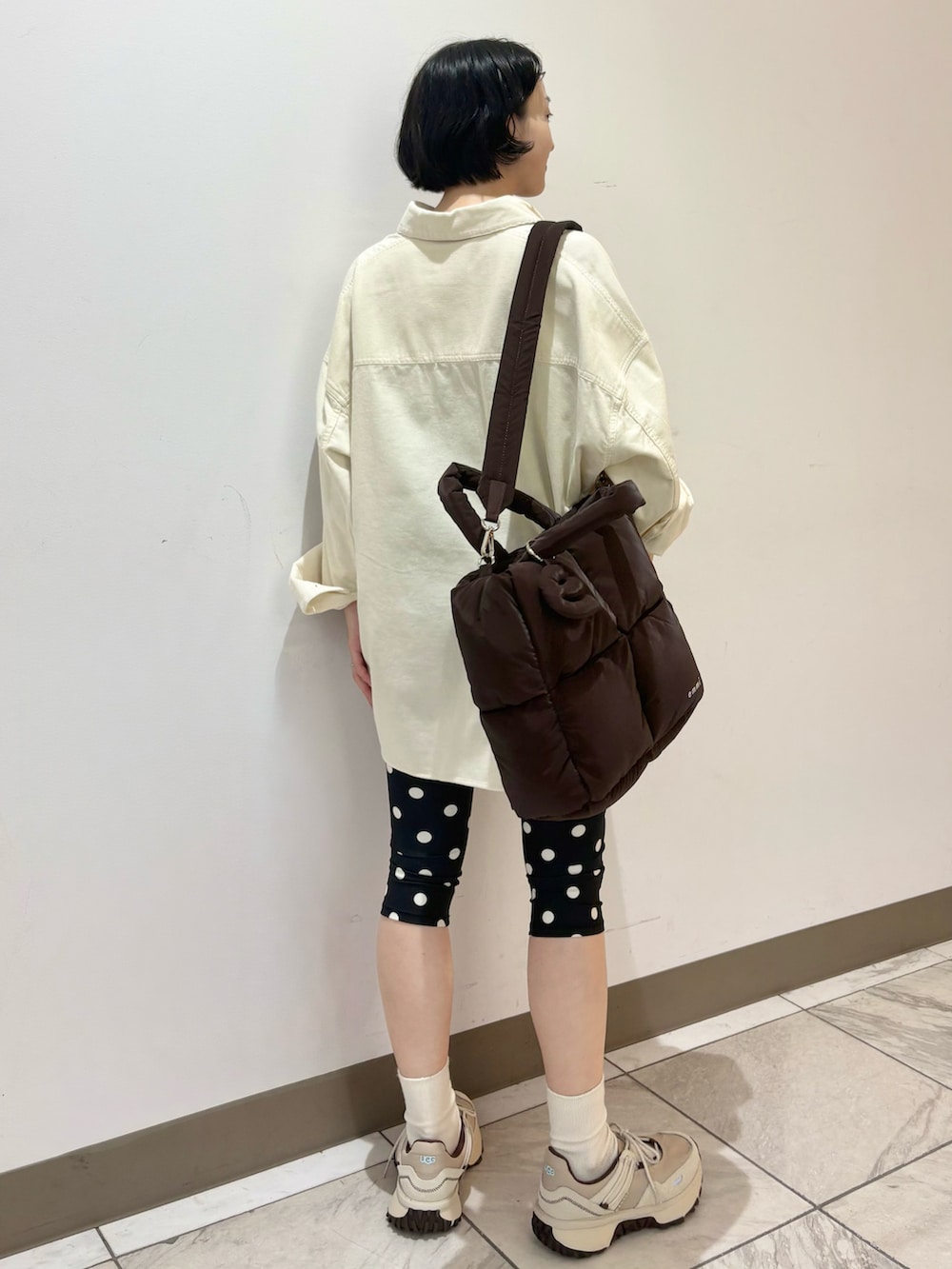 ホワイト系のシャツ/ブラウス、ベージュ系のスニーカー、ブラウン系のショルダーバッグを着用したレディースの秋コーディネートの3枚目の写真