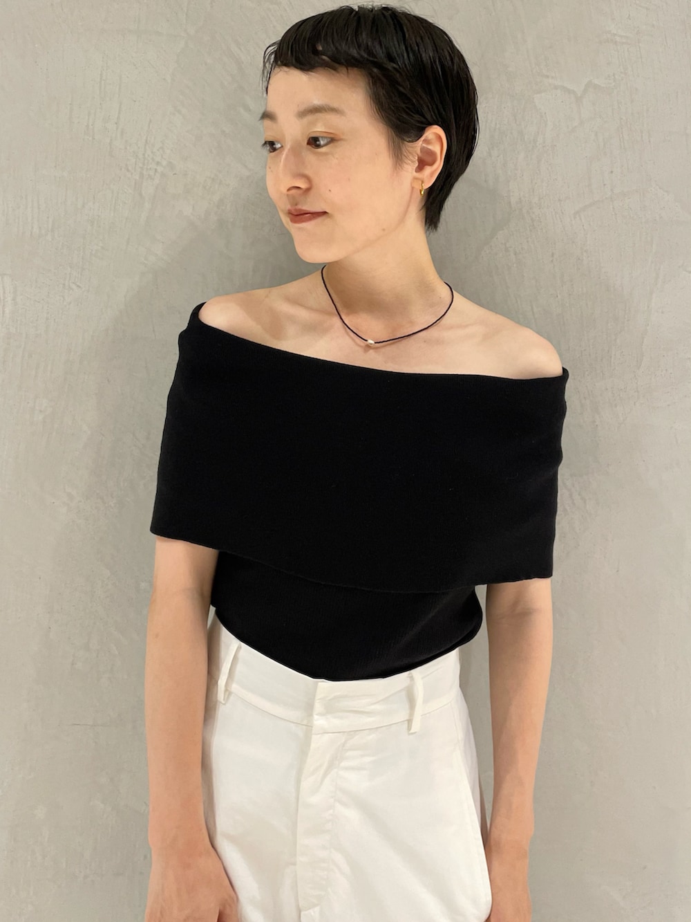 ブラック系のニット/セーター、ホワイト系のその他パンツ、ブラック系のショルダーバッグを着用したレディースの秋コーディネートの4枚目の写真