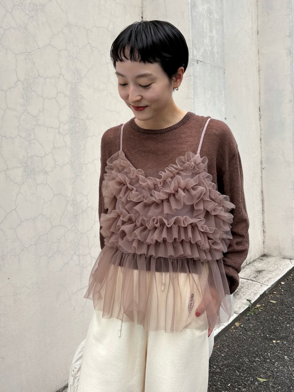 ブラウン系のニット/セーター、ブラウン系のTシャツ/カットソー、ホワイト系のスウェットパンツを着用したレディースの秋コーディネートの5枚目の写真