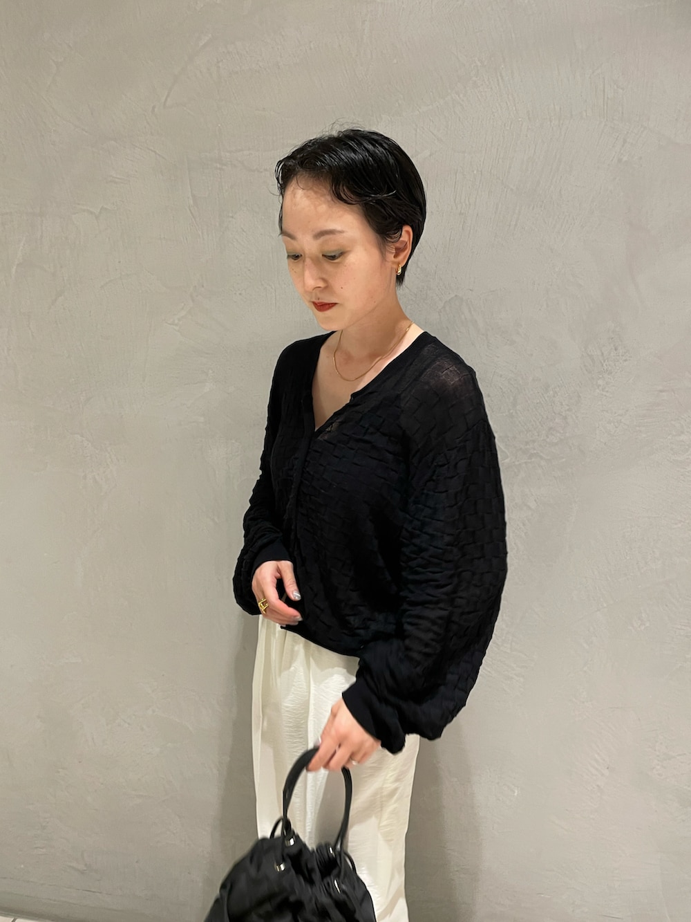 ブラック系のキャミソール、ブラック系のニット/セーター、ホワイト系のその他パンツを着用したレディースの春コーディネートの4枚目の写真