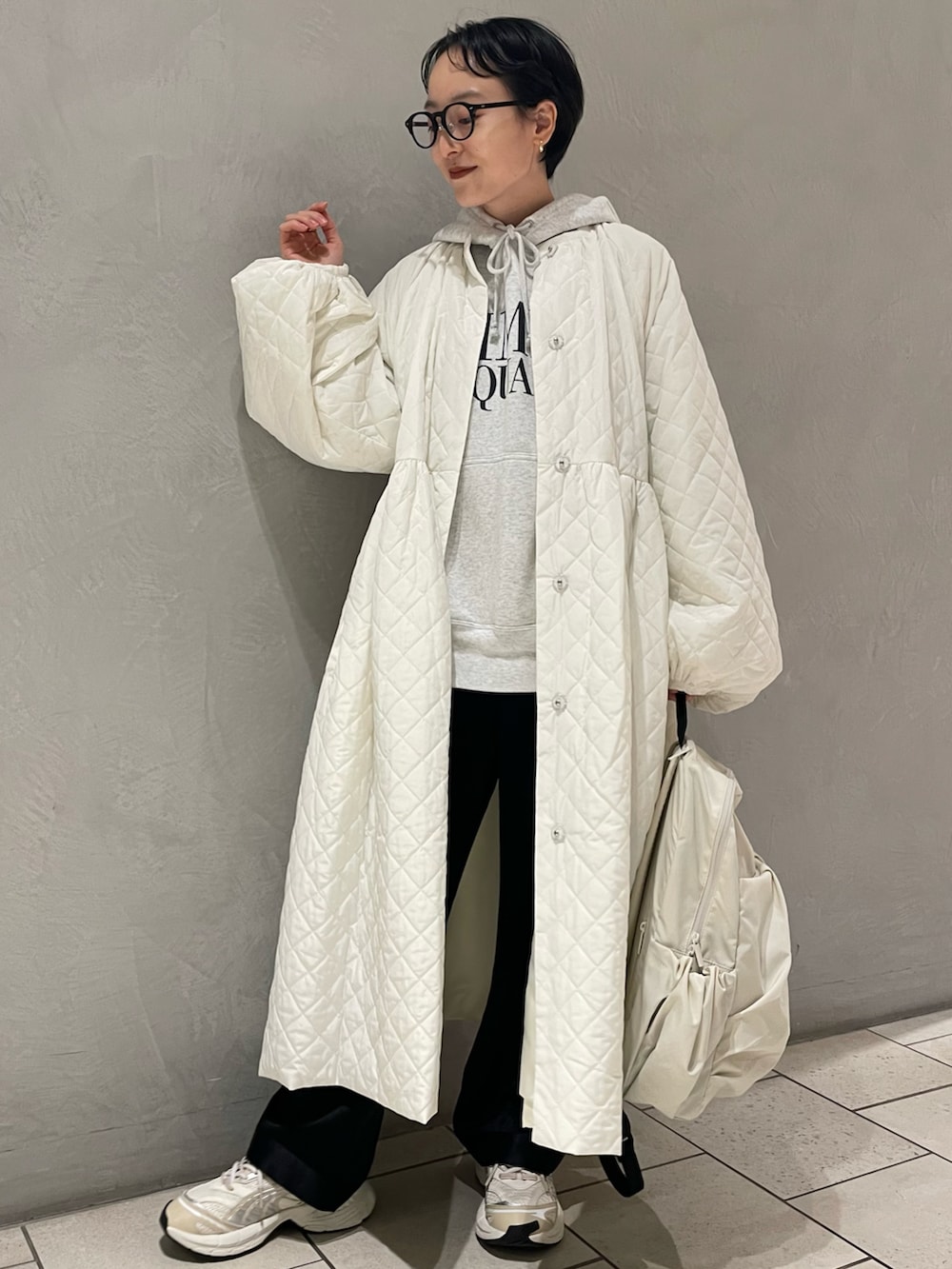 グレー系のパーカー、ホワイト系のその他アウター、ブラック系のカーゴパンツを着用したレディースの冬コーディネートの3枚目の写真