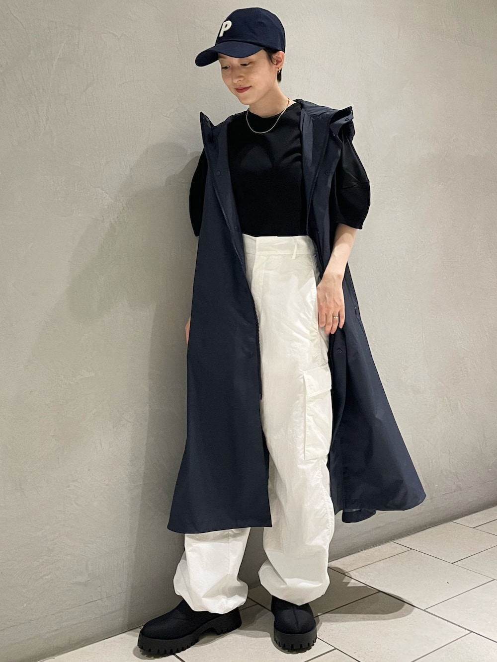 ブラック系のTシャツ/カットソー、ブルー系のナイロンジャケット、ホワイト系のその他パンツを着用したレディースの春コーディネートの2枚目の写真