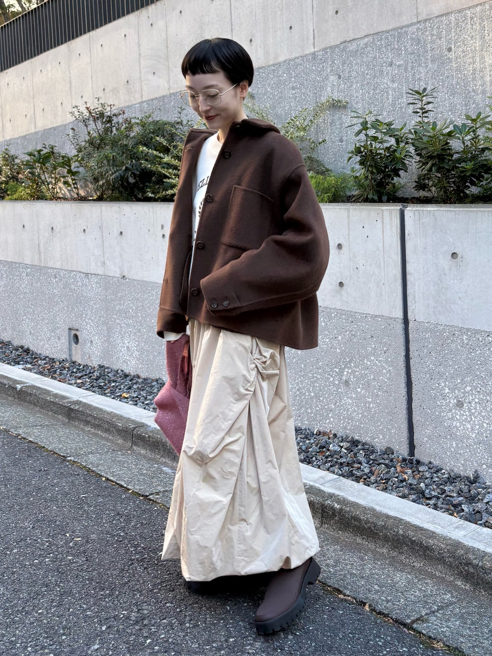 ブラウン系のチェスターコート、ホワイト系のスウェット、ベージュ系のスカートを着用したレディースの冬コーディネートの2枚目の写真