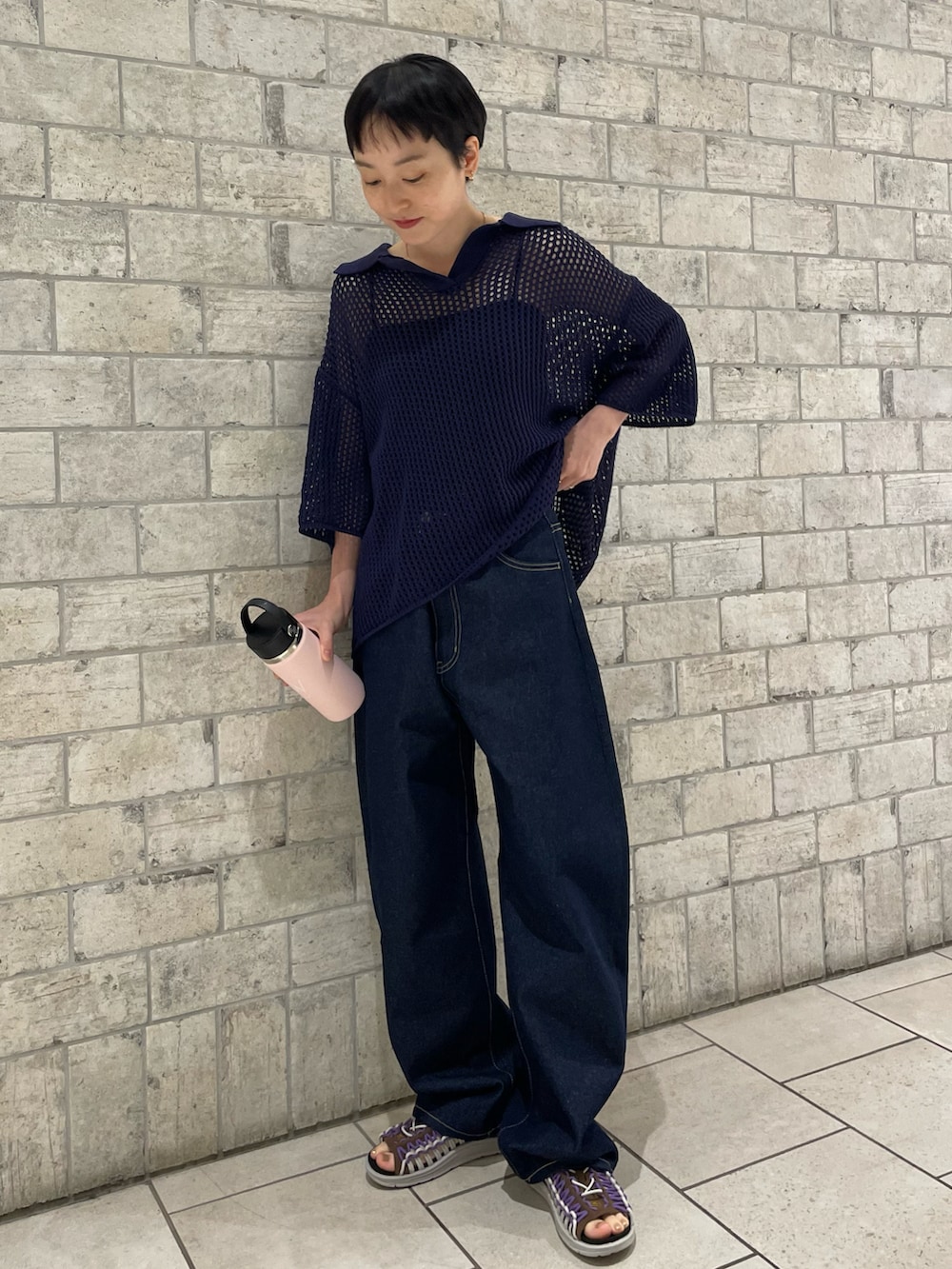 パープル系のニット/セーター、ブルー系のデニムパンツ、ブラウン系のサンダルを着用したレディースの春コーディネートの3枚目の写真
