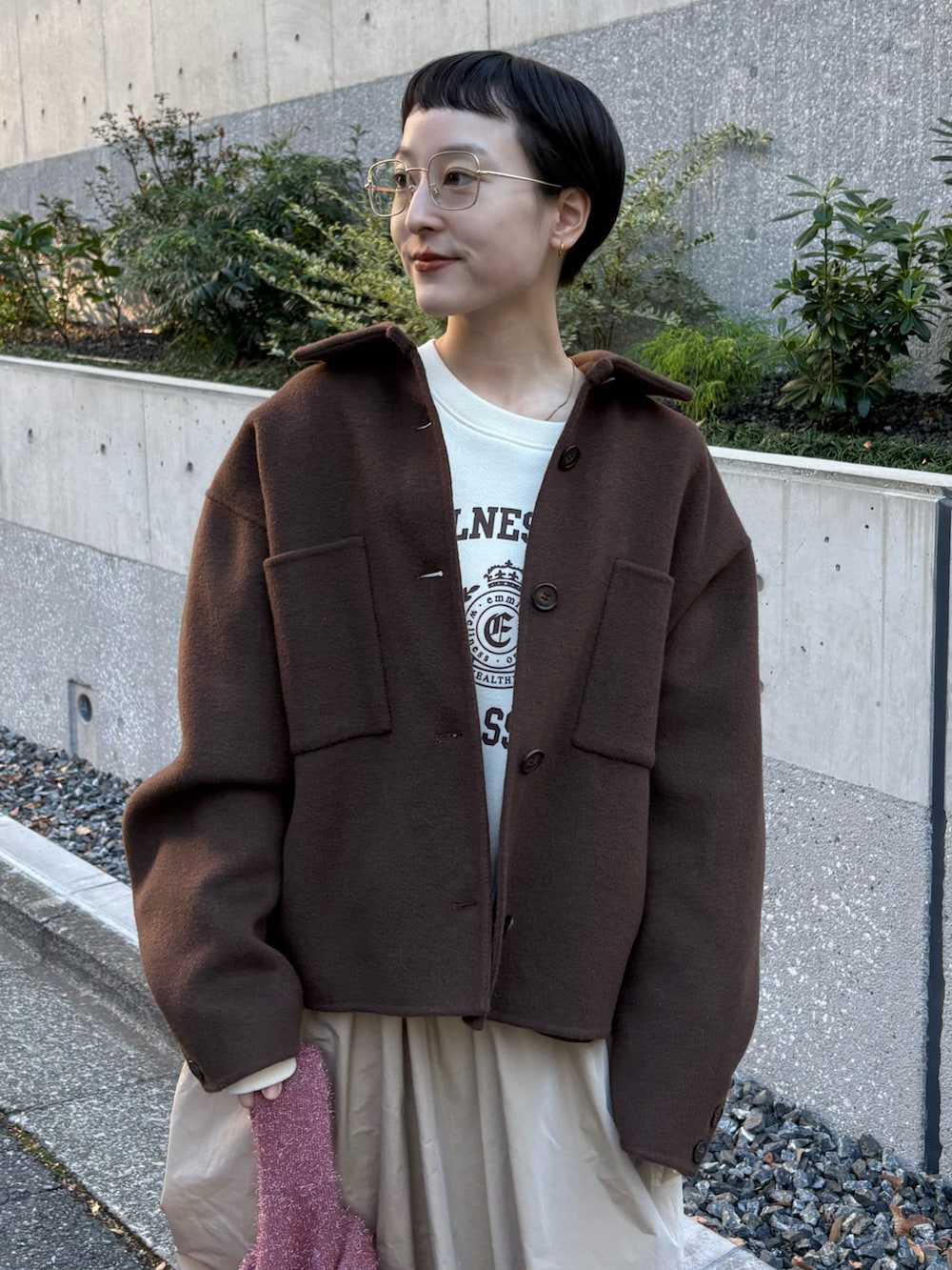 ブラウン系のチェスターコート、ホワイト系のスウェット、ベージュ系のスカートを着用したレディースの冬コーディネートの3枚目の写真