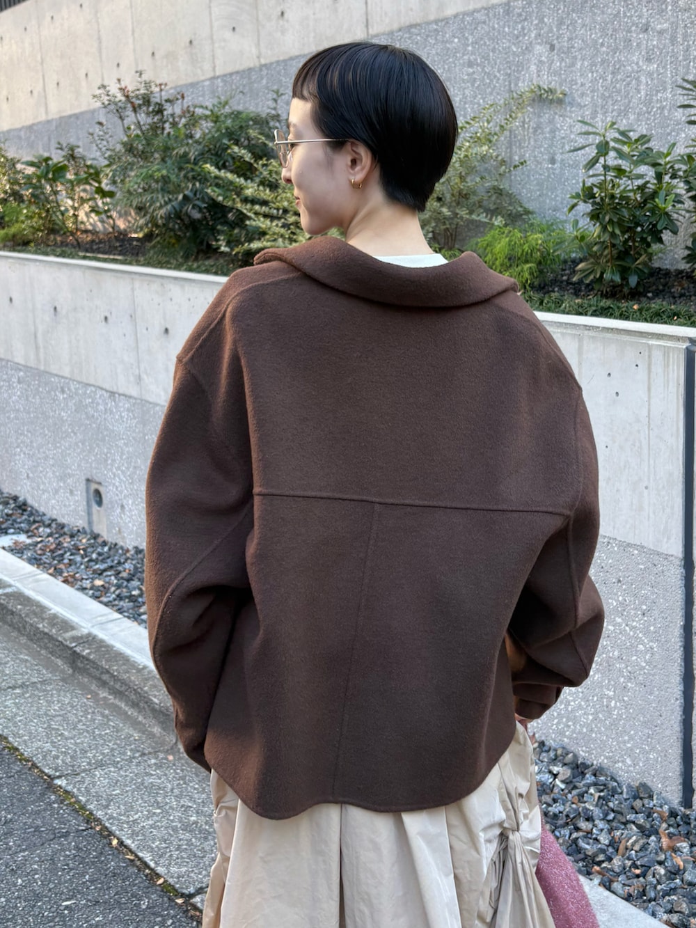 ブラウン系のチェスターコート、ホワイト系のスウェット、ベージュ系のスカートを着用したレディースの冬コーディネートの4枚目の写真