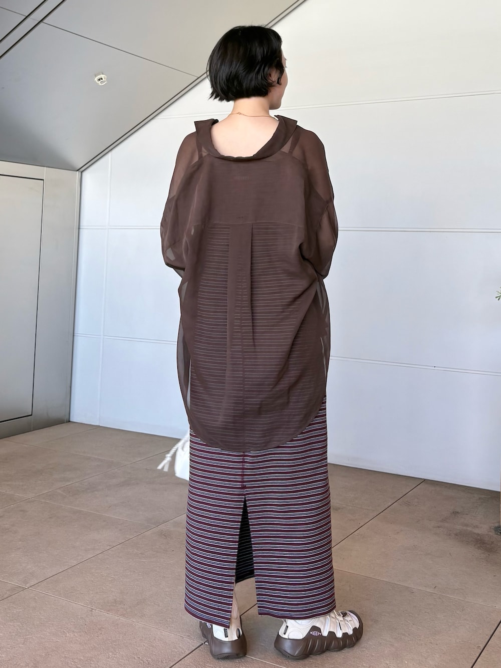 レッド系のワンピース、ホワイト系のショルダーバッグ、ベージュ系のサンダルを着用したレディースの夏コーディネートの2枚目の写真