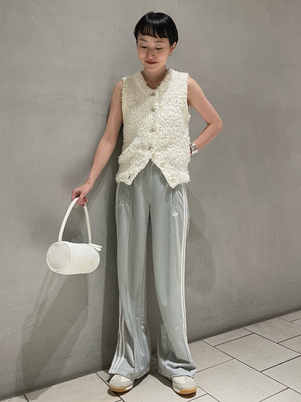ホワイト系のニット/セーター、ホワイト系のスニーカー、ホワイト系のハンドバッグを着用したレディースの春コーディネートの3枚目の写真