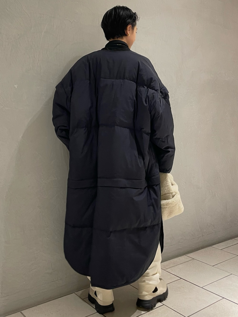 ブラック系のシャツ/ブラウス、ブルー系のダウンジャケット/コート、ホワイト系のスウェットパンツを着用したレディースの秋コーディネートの3枚目の写真