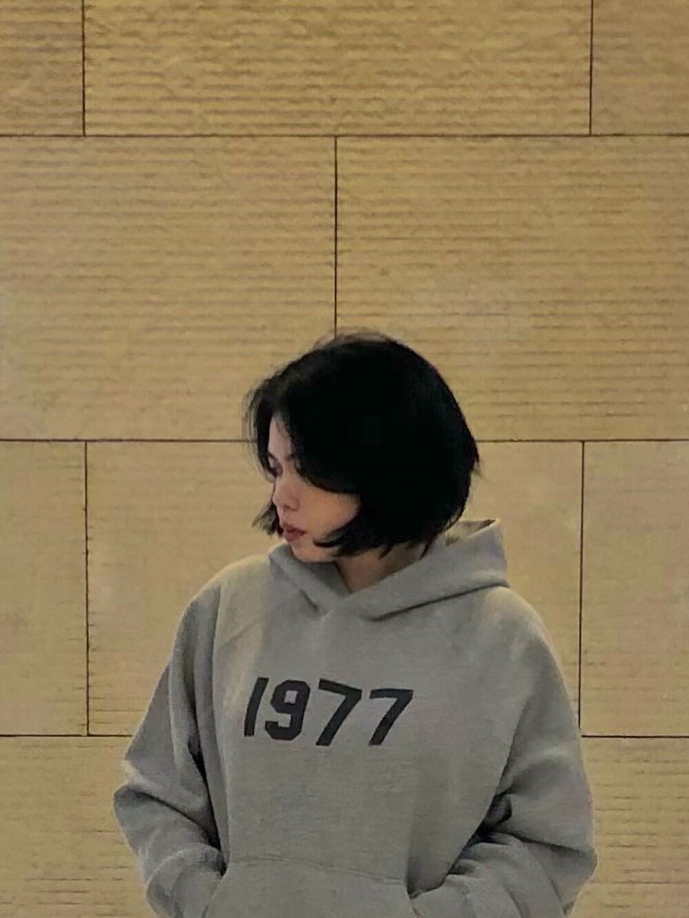 ベージュ系のカーゴパンツ、ベージュ系のパーカー、ホワイト系のスニーカーを着用したレディースの夏コーディネートの3枚目の写真