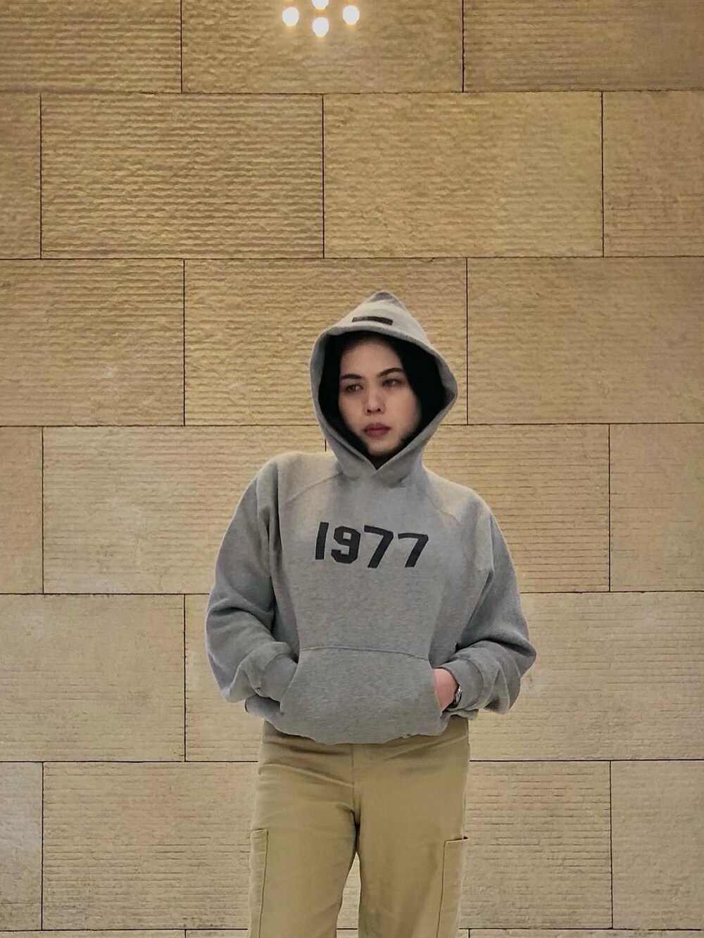 ベージュ系のカーゴパンツ、ベージュ系のパーカー、ホワイト系のスニーカーを着用したレディースの夏コーディネートの2枚目の写真