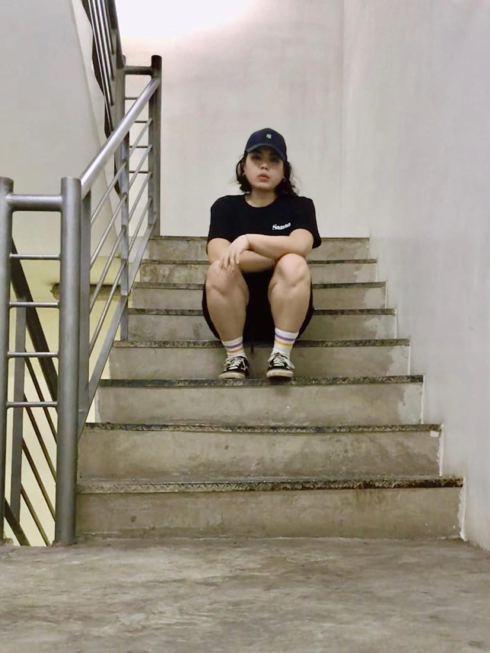 ブラック系のスニーカー、ブラック系のキャップを着用したレディースの夏コーディネートの4枚目の写真