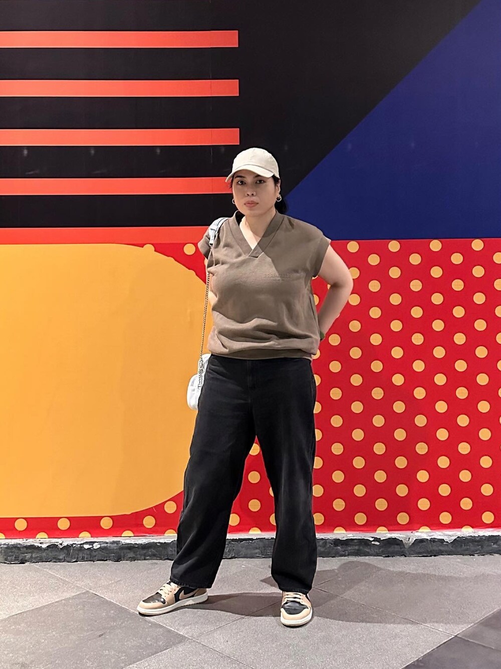 ホワイト系のスニーカー、ブラック系のデニムパンツ、ブルー系のショルダーバッグを着用したレディースの冬コーディネートの2枚目の写真