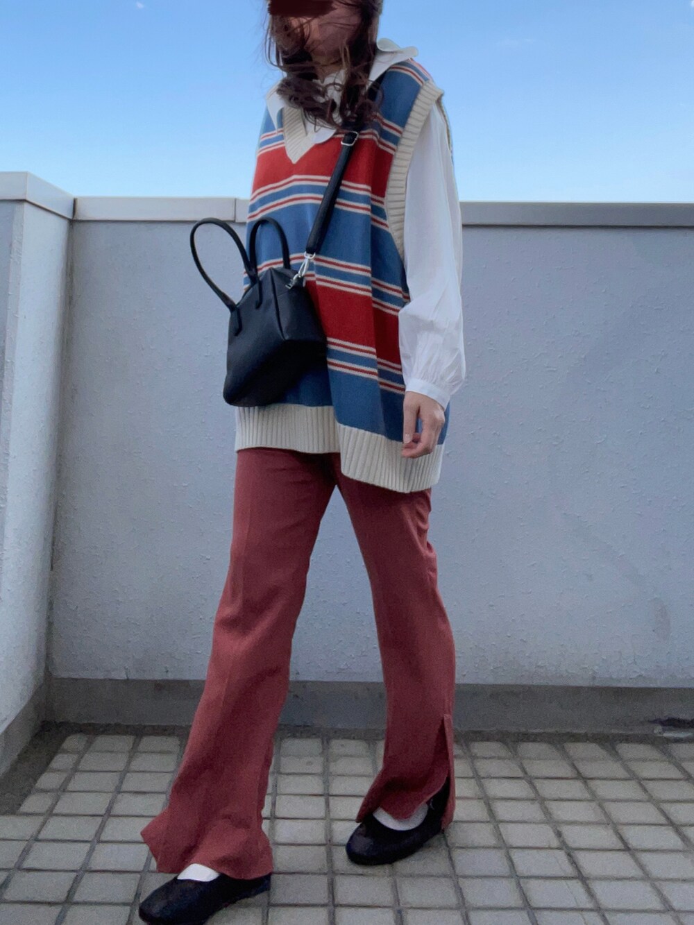 ホワイト系のシャツ/ブラウス、ブルー系のベスト、ブラック系のボストンバッグを着用したレディースの春コーディネートの3枚目の写真