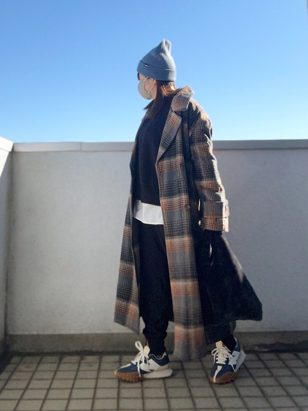 ブラウン系のチェスターコート、ブラック系のニット/セーター、ブラック系のその他パンツを着用したレディースの冬コーディネートの3枚目の写真