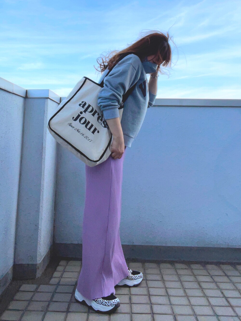 グレー系のスウェット、ピンク系のスカート、その他のスニーカーを着用したレディースの春コーディネートの3枚目の写真