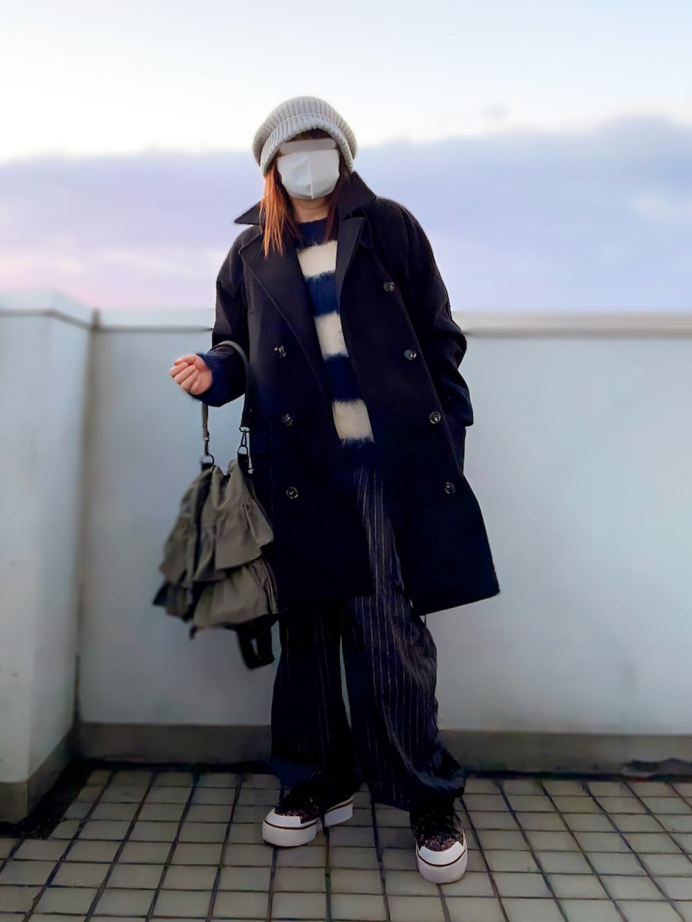 ブラック系のピーコート、ブルー系のニット/セーター、グレー系のカーゴパンツを着用したレディースの冬コーディネートの3枚目の写真