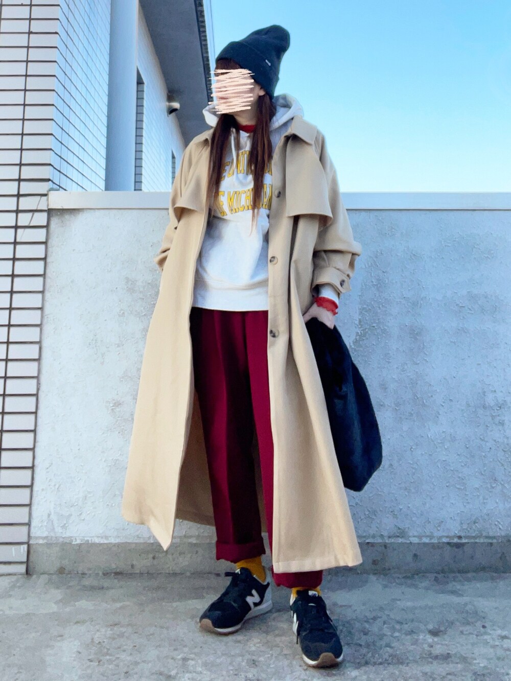 ベージュ系のトレンチコート、オレンジ系のトップス、その他のバッグを着用したレディースの秋コーディネートの2枚目の写真