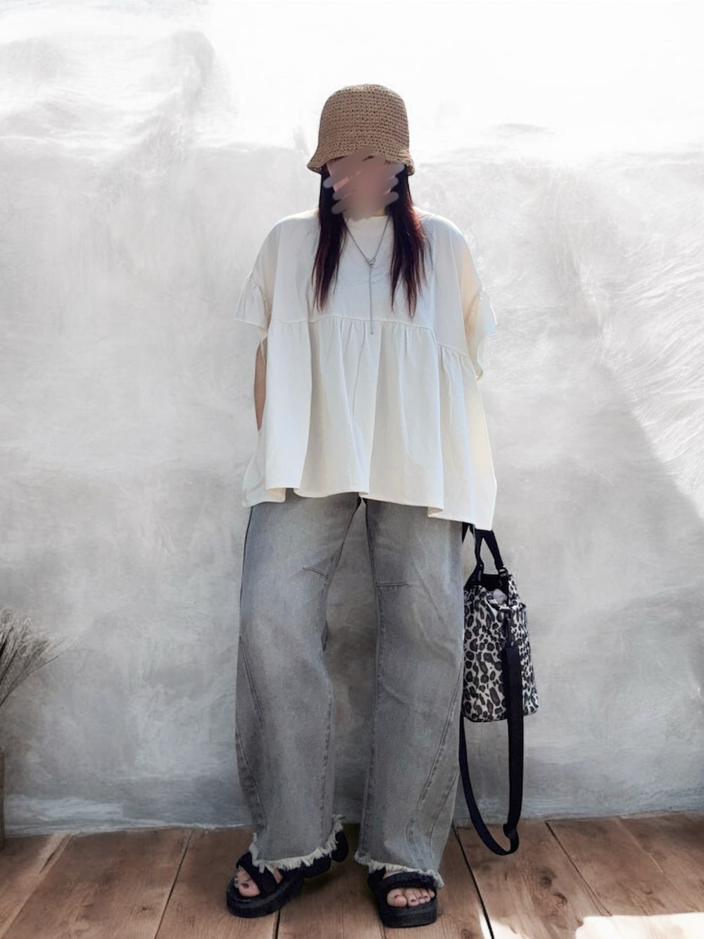 グレー系のデニムパンツ、ブラック系のサンダル、ベージュ系のショルダーバッグを着用したレディースの夏コーディネートの2枚目の写真