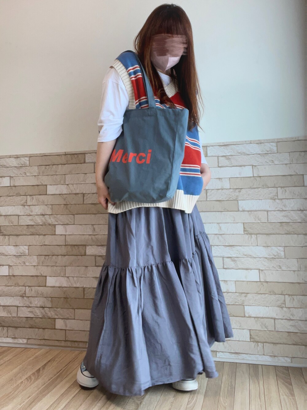 ブルー系のベスト、ホワイト系のTシャツ/カットソー、ブルー系のトートバッグを着用したレディースの春コーディネートの2枚目の写真