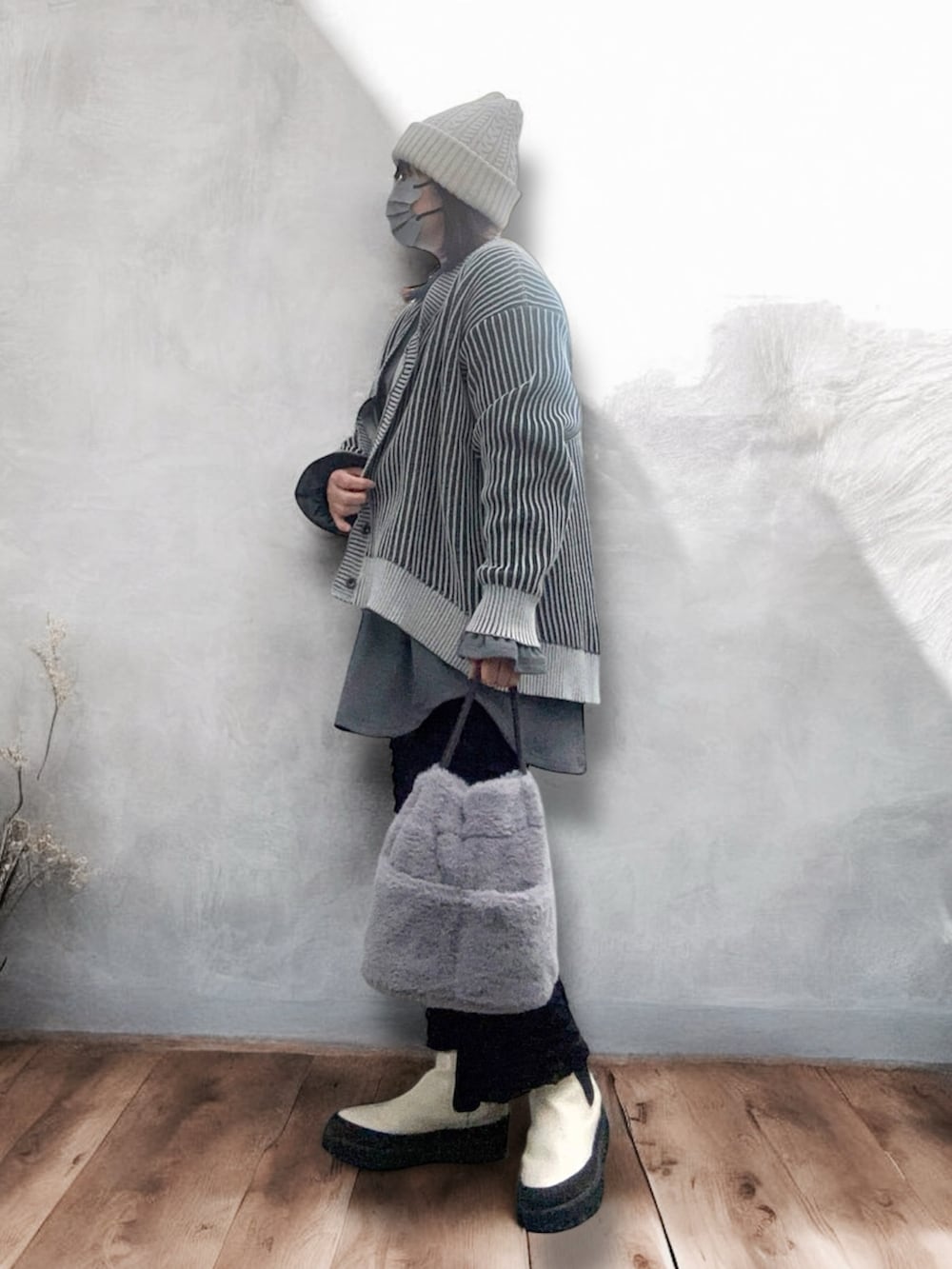 ホワイト系のブーツ、ブラック系のスカート、ブラック系のカーディガン/ボレロを着用したレディースの冬コーディネートの3枚目の写真