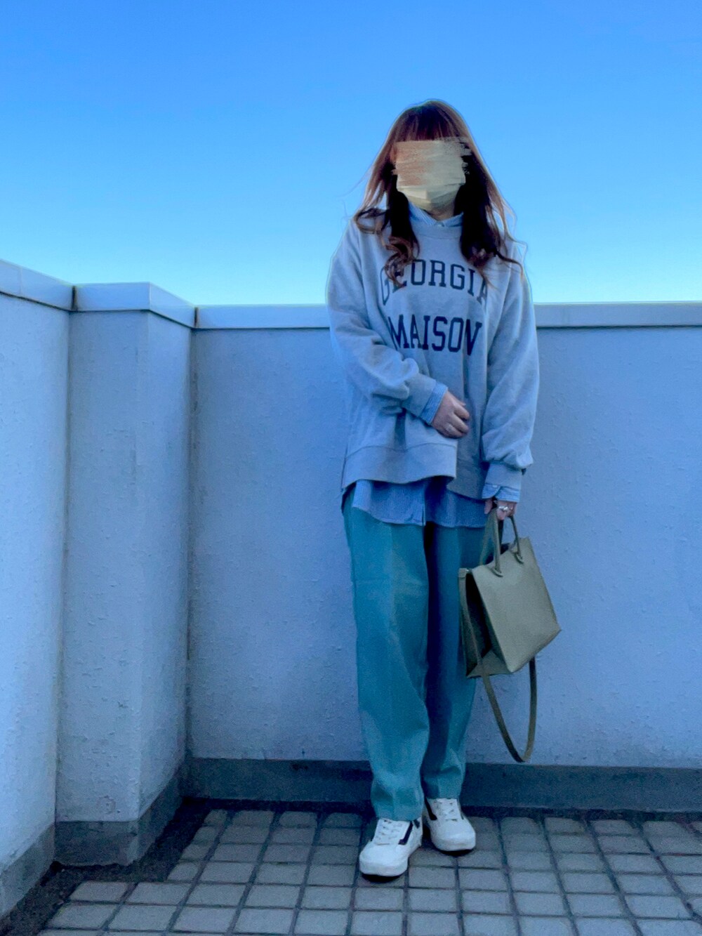 グレー系のスウェット、グリーン系のダウンジャケット/コート、グリーン系のショルダーバッグを着用したレディースの冬コーディネートの2枚目の写真