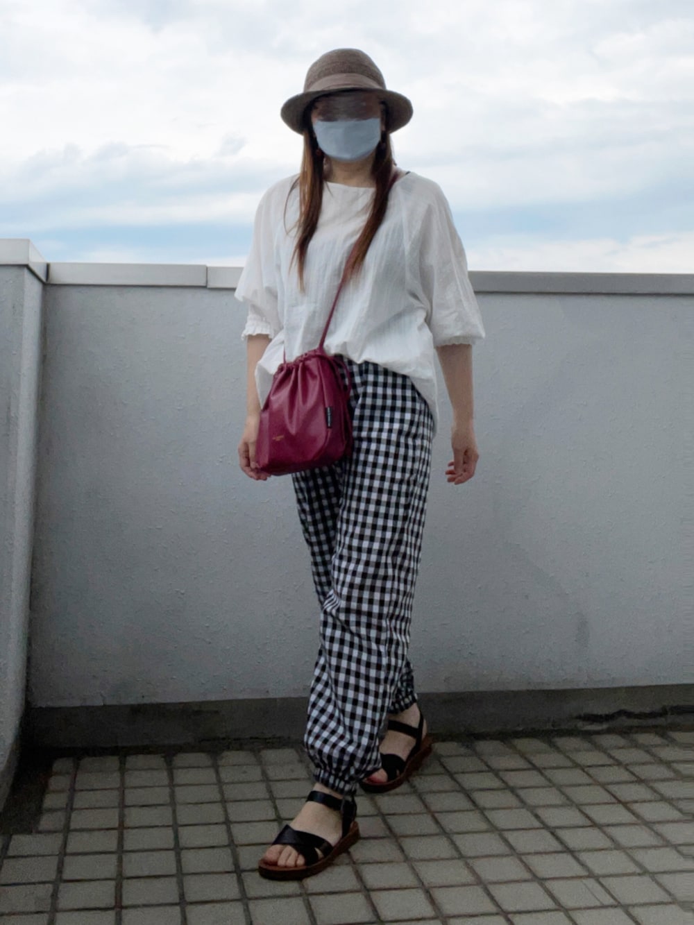 ホワイト系のシャツ/ブラウス、ブラック系のパンツ、ブラック系のサンダルを着用したレディースの夏コーディネートの2枚目の写真