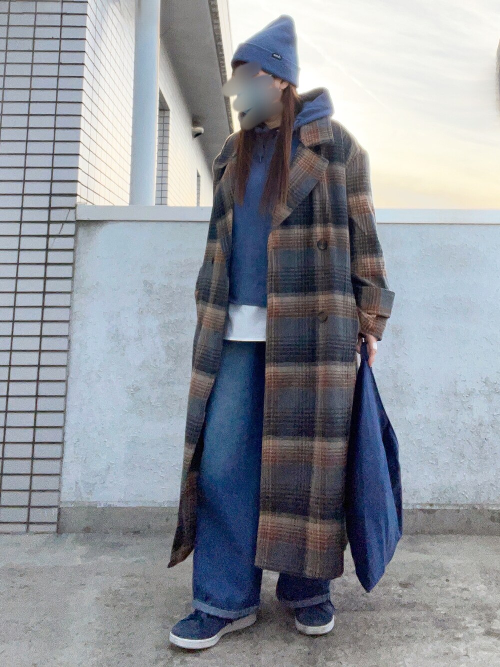ブラウン系のチェスターコート、ブルー系のパーカー、ブルー系のスニーカーを着用したレディースの冬コーディネートの4枚目の写真