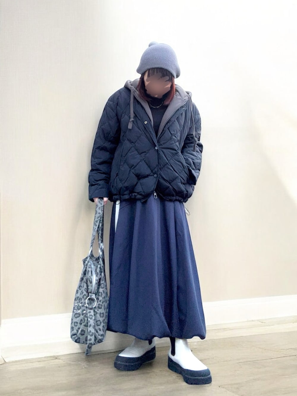 ブラック系のダウンジャケット/コート、グレー系のスカート、グレー系のボストンバッグを着用したレディースの冬コーディネートの2枚目の写真