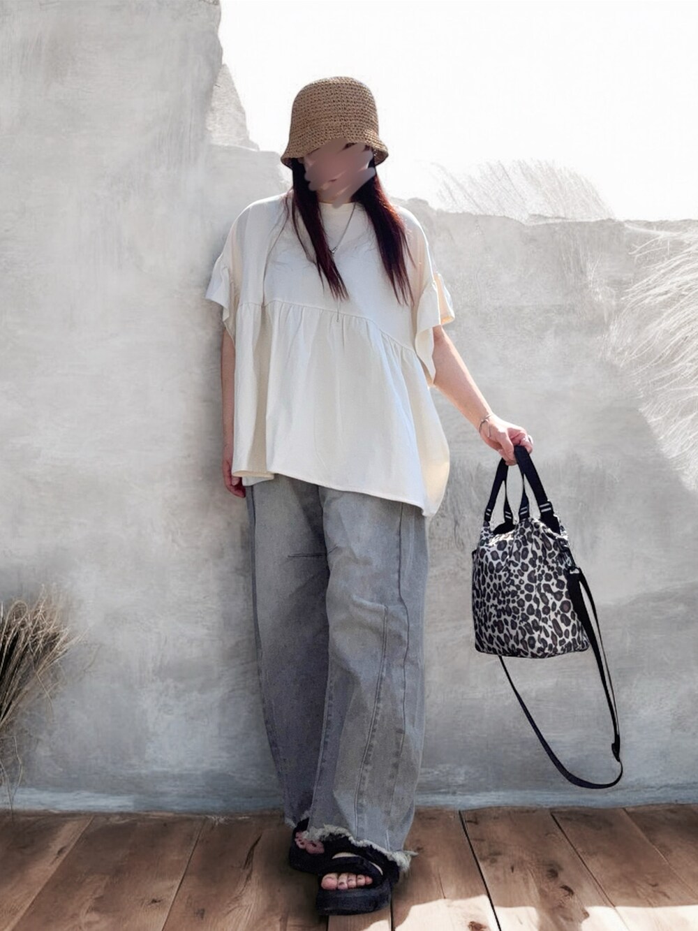 グレー系のデニムパンツ、ブラック系のサンダル、ベージュ系のショルダーバッグを着用したレディースの夏コーディネートの3枚目の写真