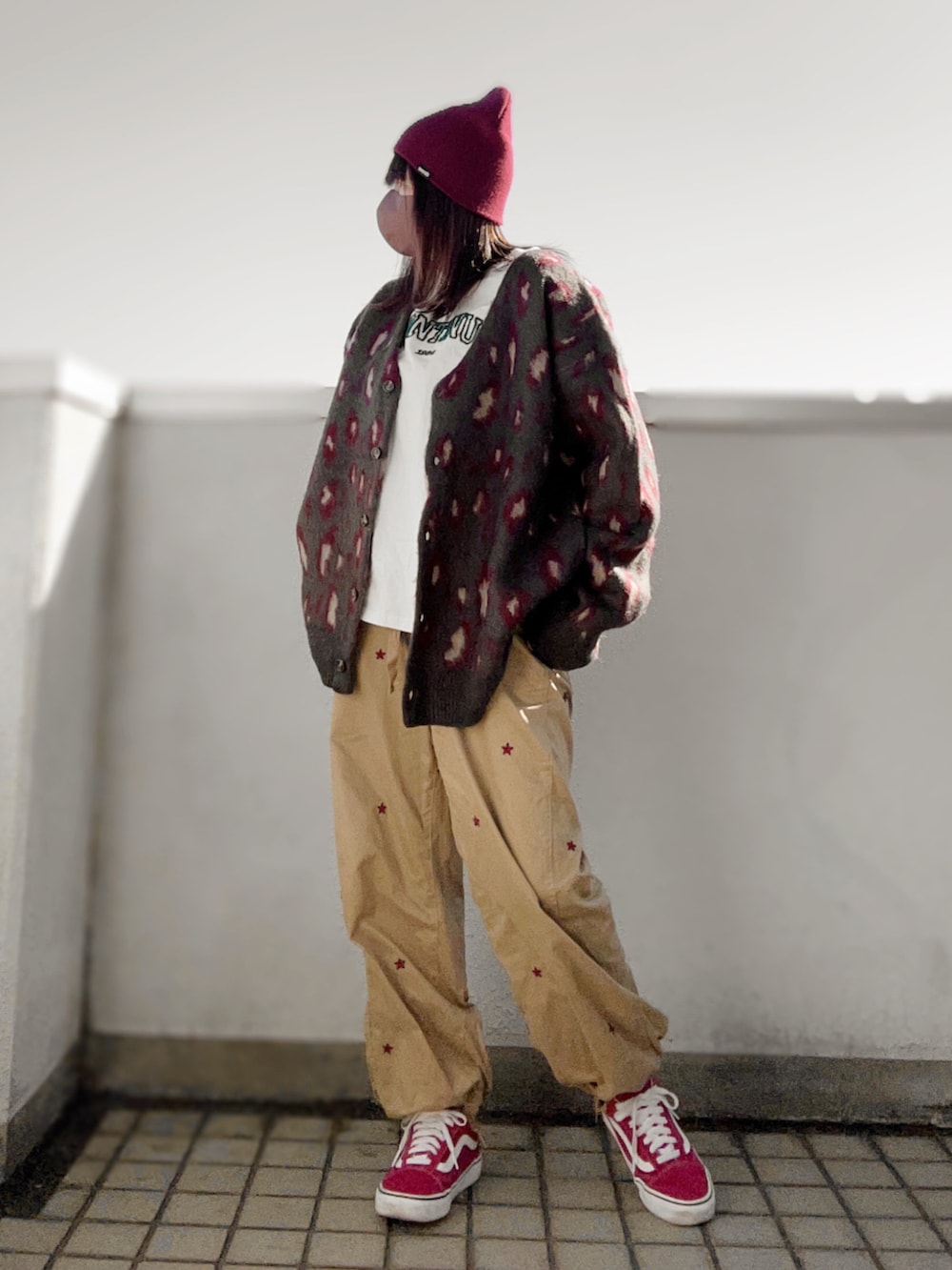 レッド系のカーディガン/ボレロ、イエロー系のその他パンツ、ピンク系のスニーカーを着用したレディースの冬コーディネートの3枚目の写真